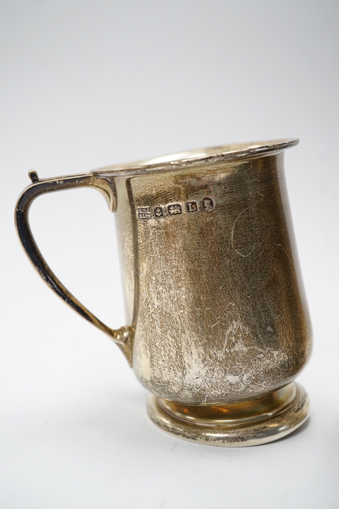 Six items of small silver:- two christening mugs, a cream jug, a salt, an egg cup and a box lid. Condition - poor to fair